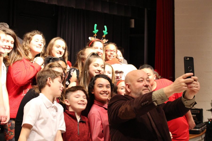 Mr. Keith Kovalic, choir director, takes a selfie with members of the choir during their concert on Dec. 12 at Freedom Middle School.