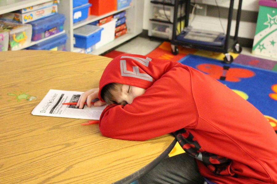 Sixth grader Tyler Misencik falls asleep while editing newspaper articles on Feb. 6 due to lack of sleep.