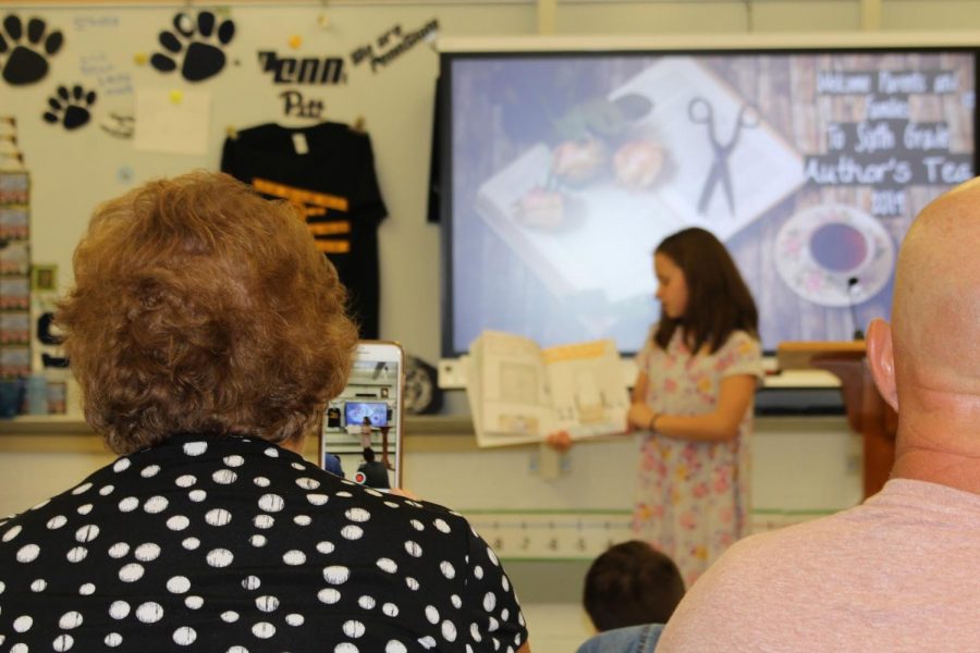Parents watch as students present their childrens book 