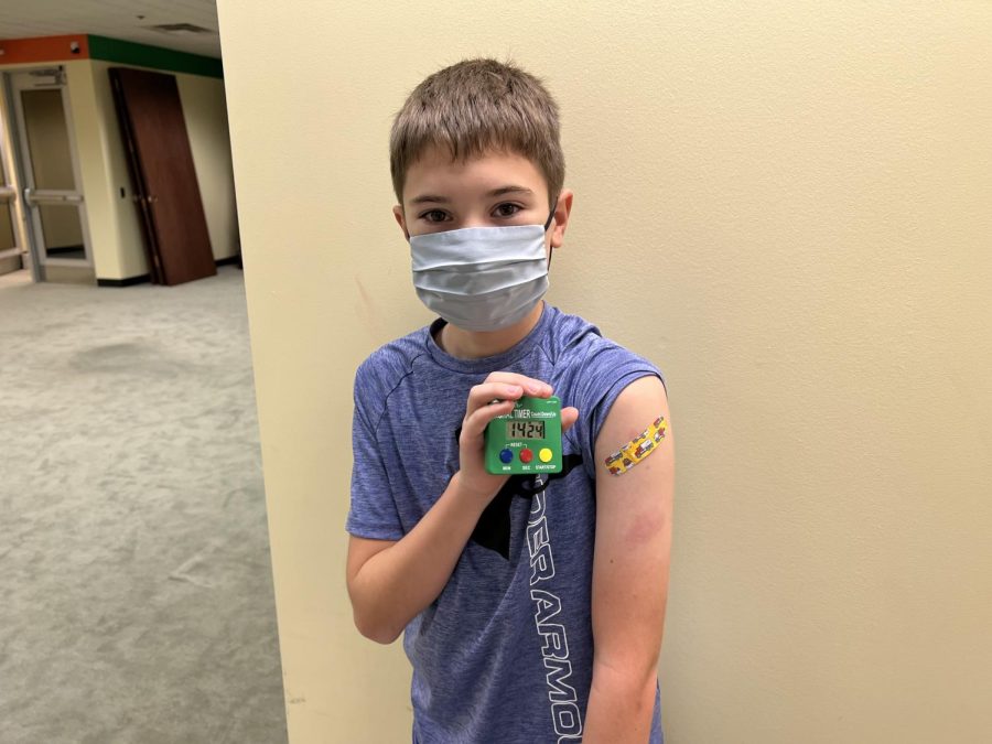 Wyatt Miller holds his 15-minute timer after he recived his first dose of the COVID-19 vaccine on Nov. 18. 