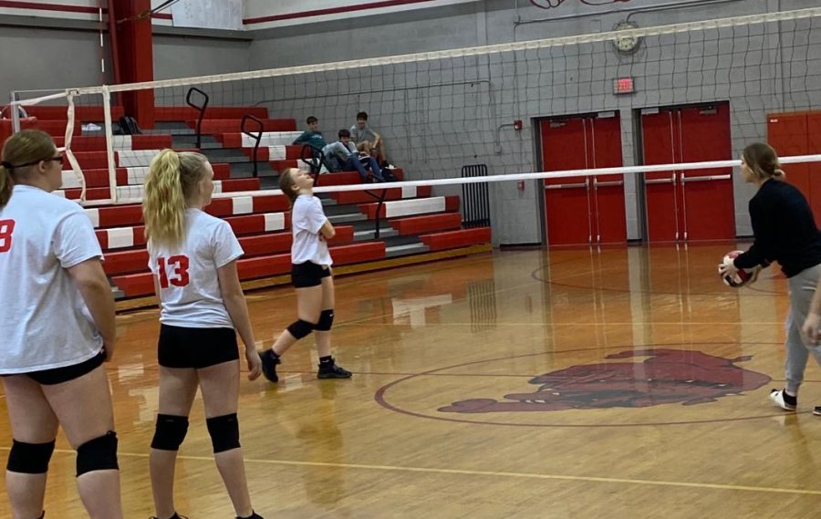 Kallie Brown, Trinity Vojtko, and Alyssa Bearer warm up before the girls volleyball game on Feb. 24 in the middle school gym. 