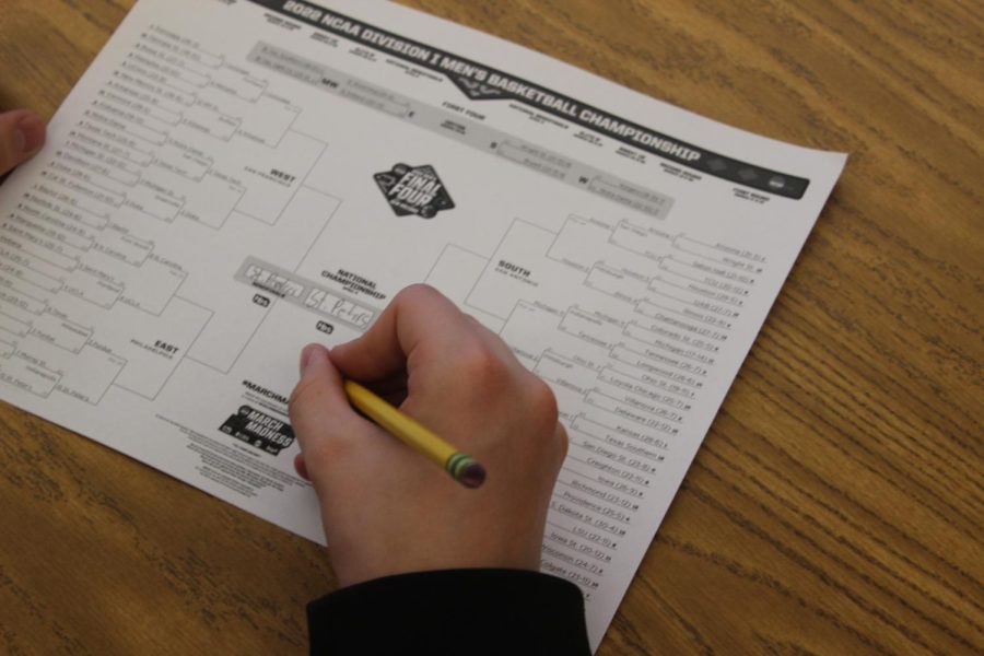 Nicholas Metzger fills out a bracket for his projected winners of March Madness.