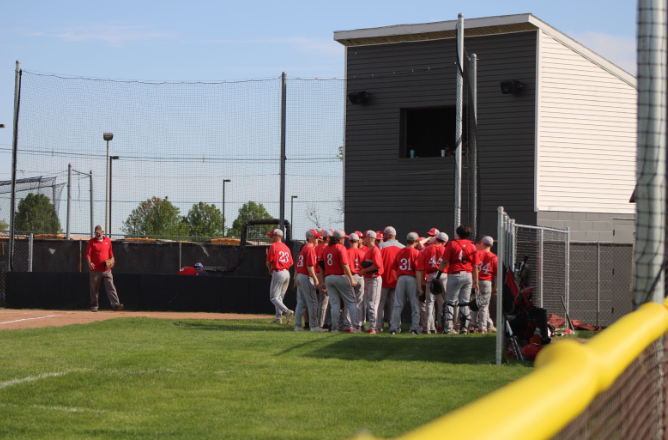 The+baseball+team+in+a+huddle+before+playing+in+a+game+against+the+Blackhawk+Warriors.%0A