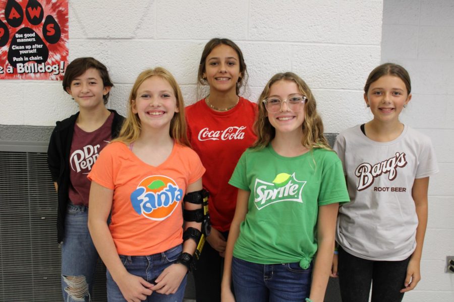 Seventh grade students, Caroline Bender, Gracy Stewart, Cameron Stumpf, Hannah Houy, and Annabella Daniele, pose for picture while wearing matching soda shirts, for group day. 

