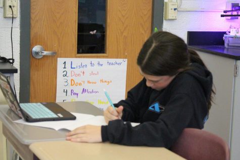 Sixth grade honors math student Jordyn Moehrle works on her pizza box project in math class. 