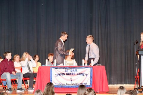  Lucas Bradel receives his certificate and pin from Dr. Ryan Smith, principal, as current 8th and 9th grade students are inducted into National Junior Honor Society on May 20.
