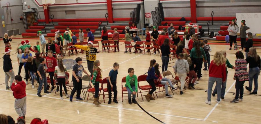 Students wearing ugly Christmas sweaters participate in musical chairs during the PAWS holiday assembly in the gym on Dec. 22. 