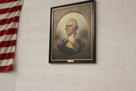 The portrait of former president George Washington hanging in the middle school auditorium.