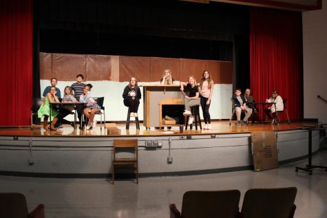 The middle school play cast is practicing scene five in the auditorium.