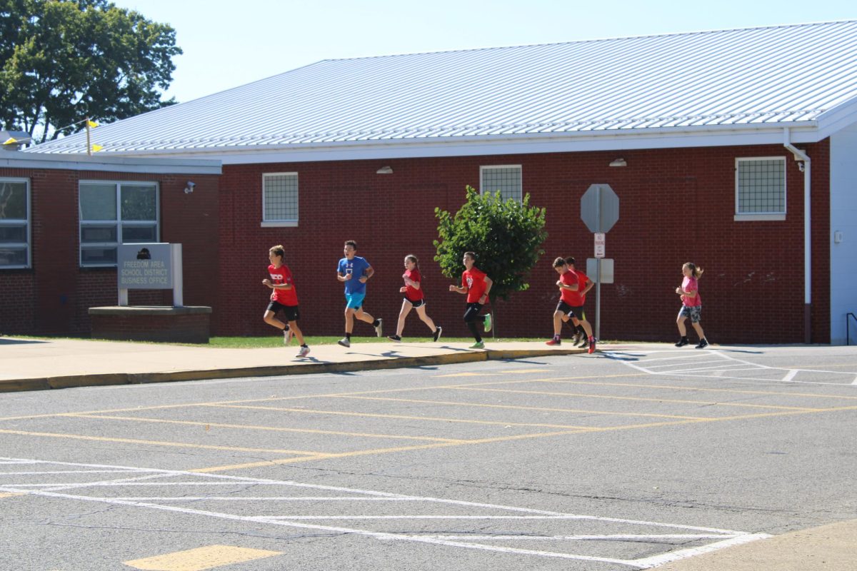  Junior high cross country team running in front of the middle school during practice.
