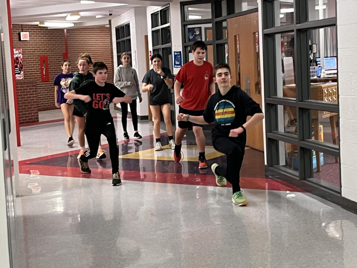 Track and field team warming up for practice inside the school.