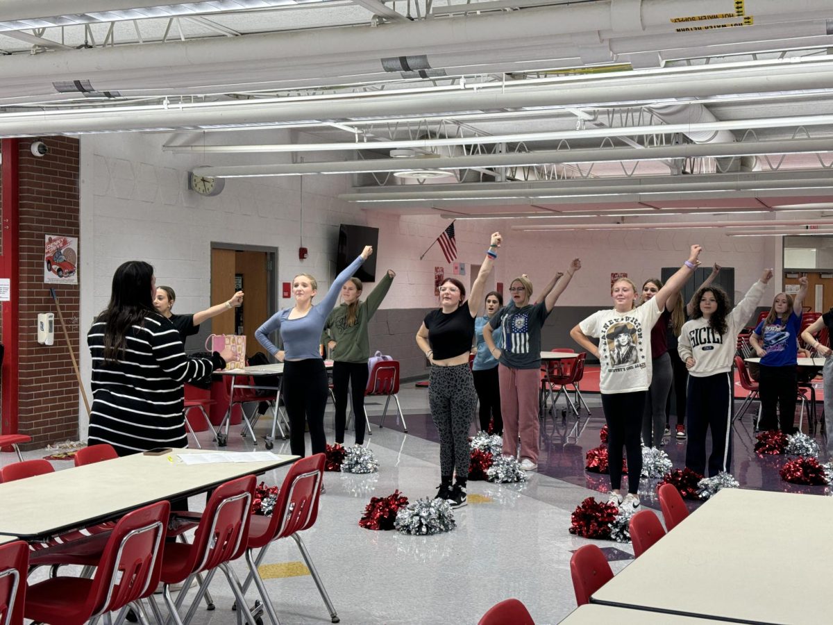 Cheerleaders practicing in the cafeteria.