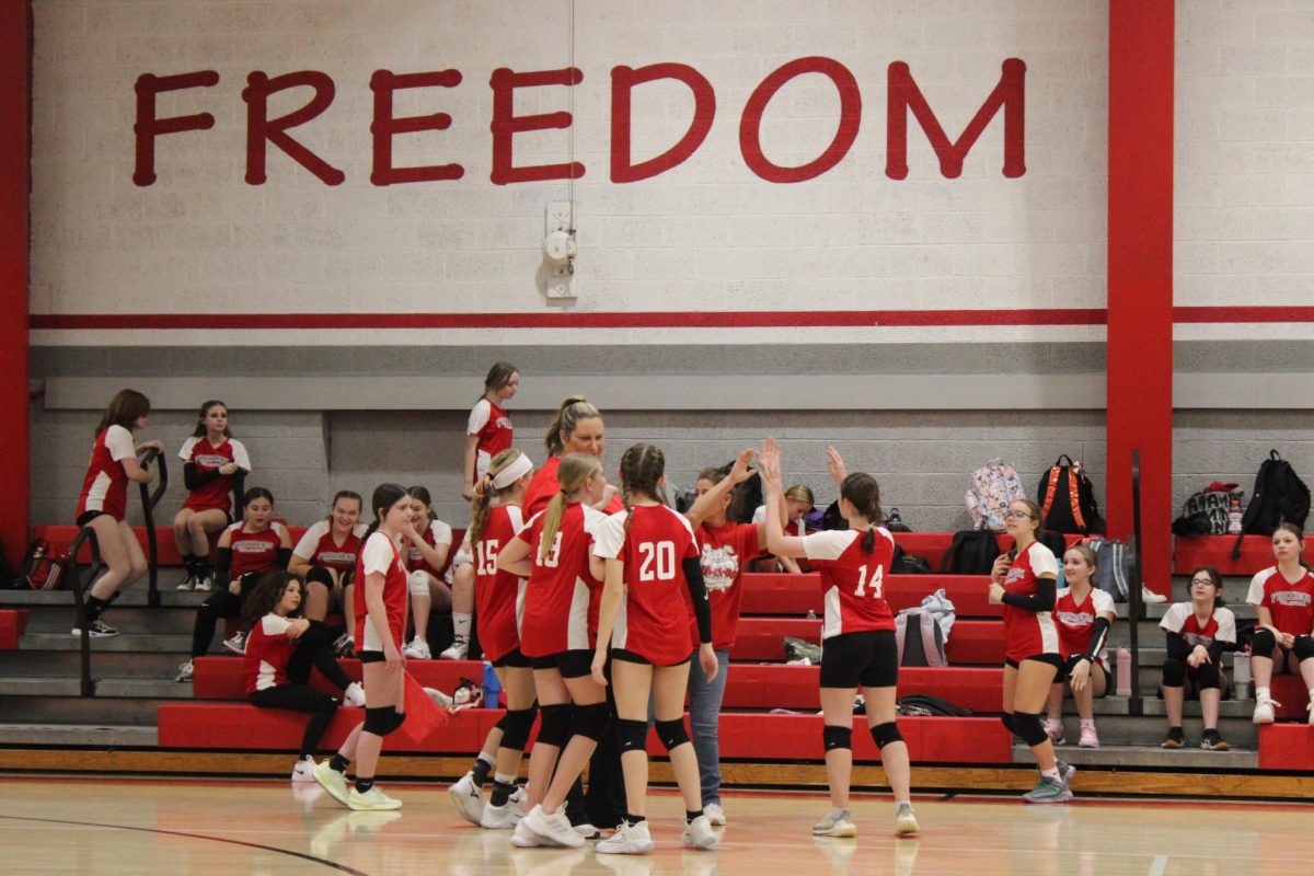 The volleyball team plays against Union huddling up after the first set in the middle school gymnasium on Thursday, February 20. 