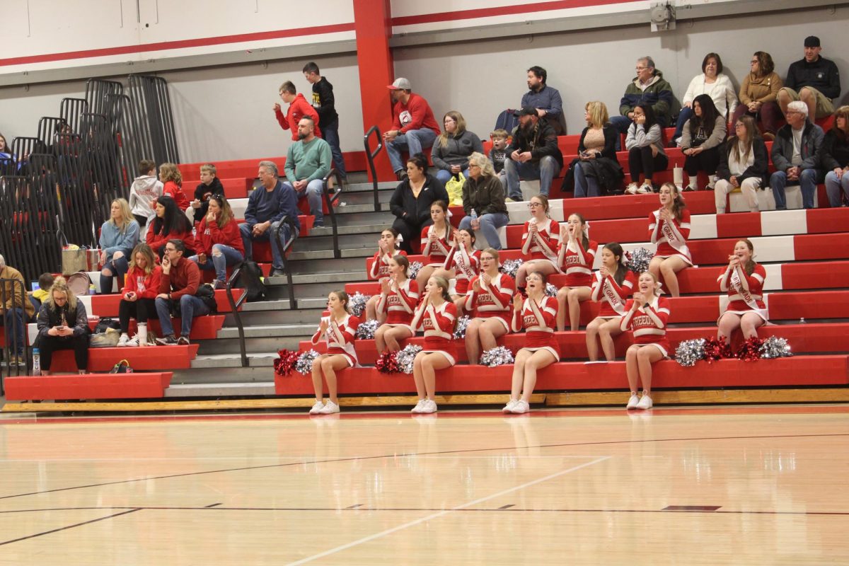 Middle school cheerleaders at their last home February 4 game, cheering on the basketball boys in the gymnasium. 