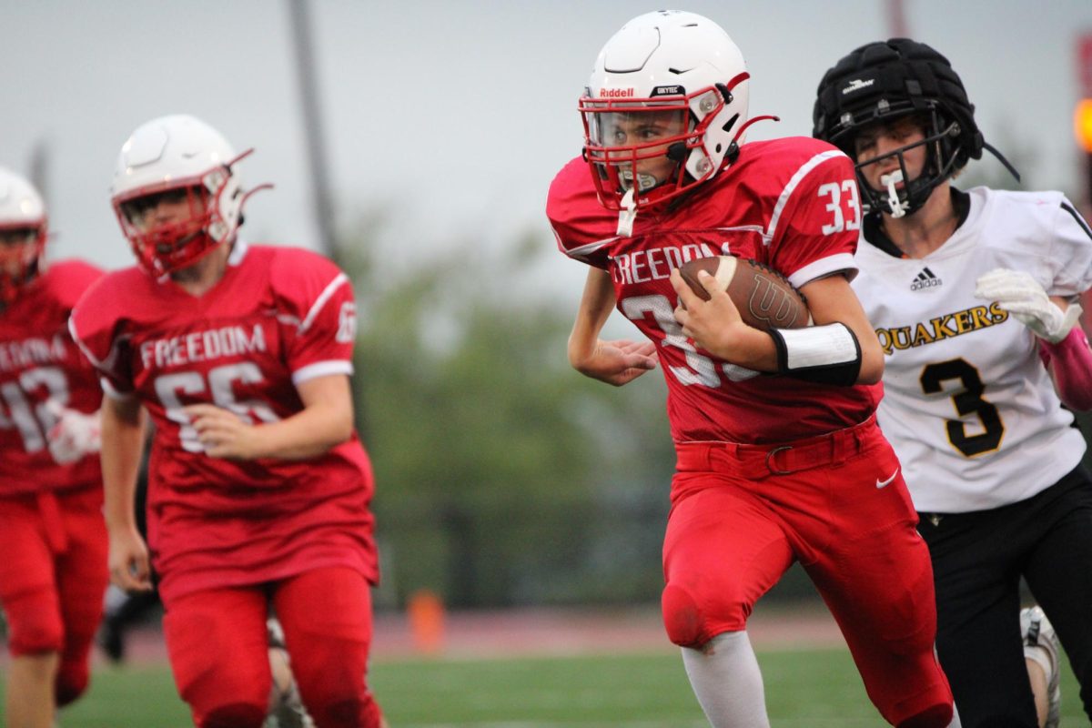 Chase Furman, running back on the football team, runs the ball downfield while playing Quaker Valley at home on Sept. 24.