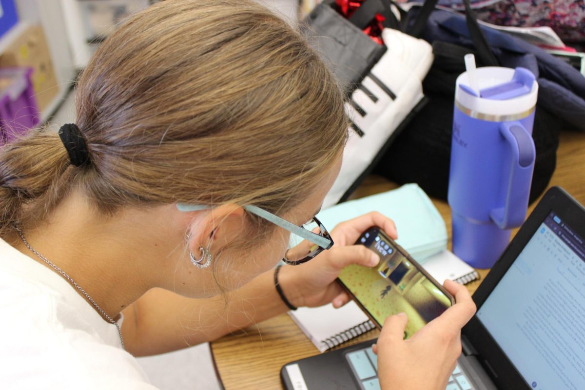 Kaylee Anderson (8) plays Roblox on her phone