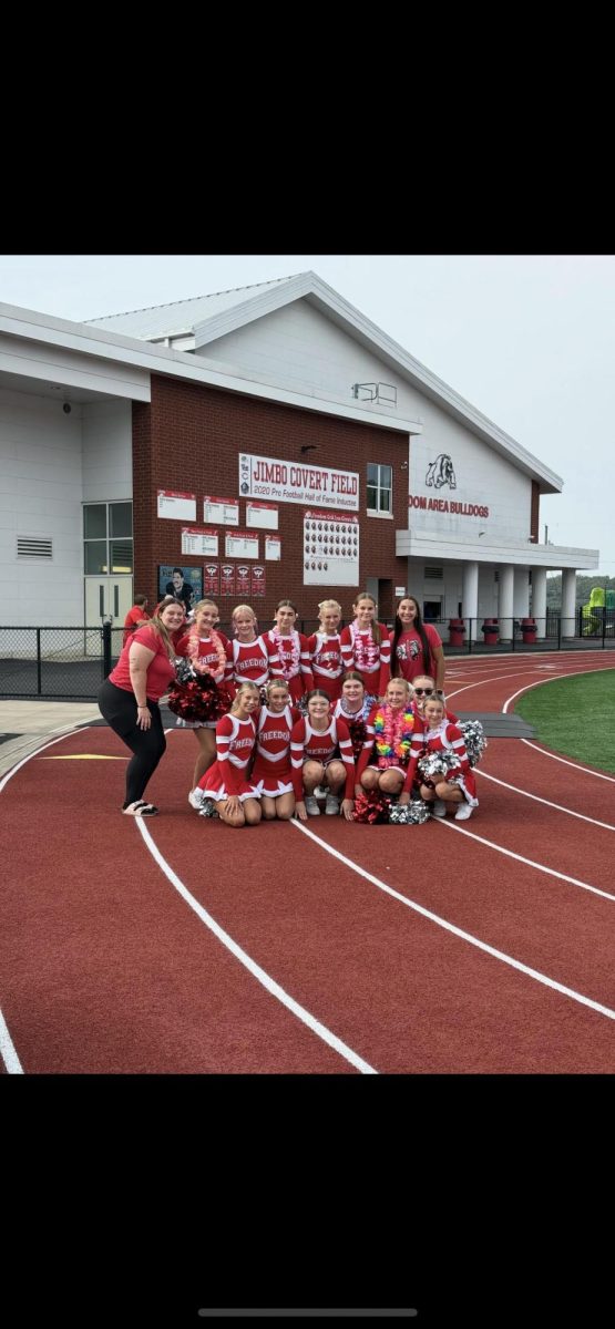 Cheerleaders getting a group photo before game cheering with varsity on a Saturday morning.