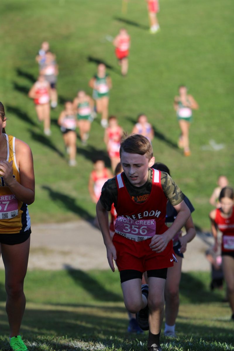 Isaac Mattern (7), cross country runner, sprints up a hill during the MAC meet at Brush Creek Park on Wednesday, Oct. 8.