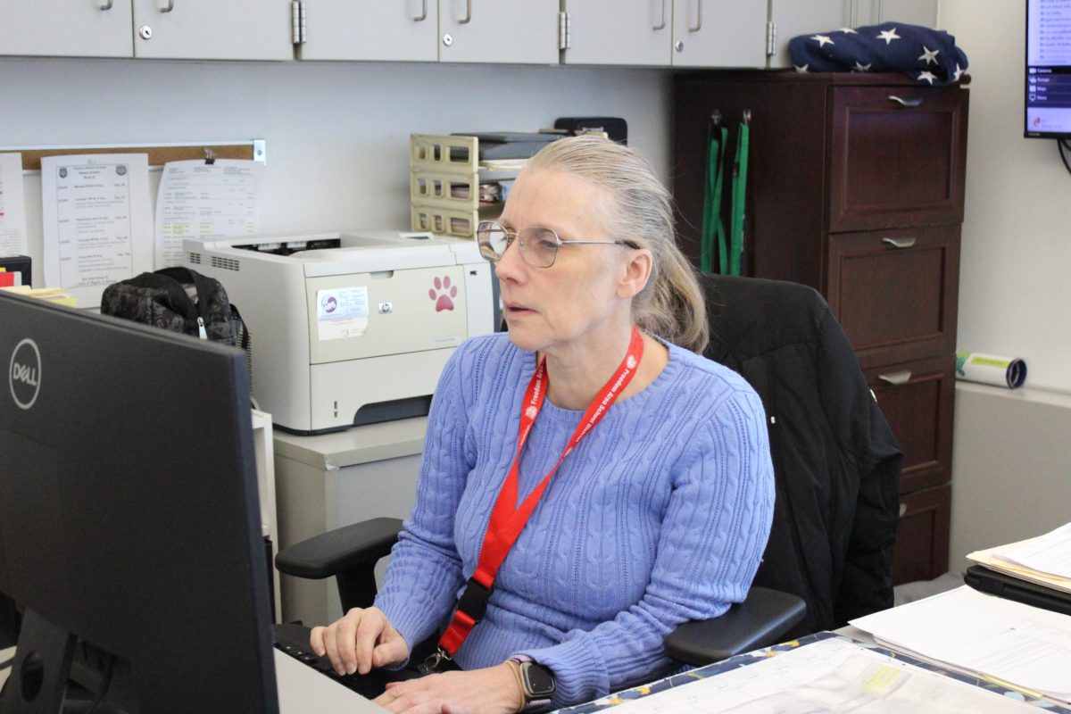 Ms. Susan Wilkinson sits in the Freedom Middle School office working as secretary.