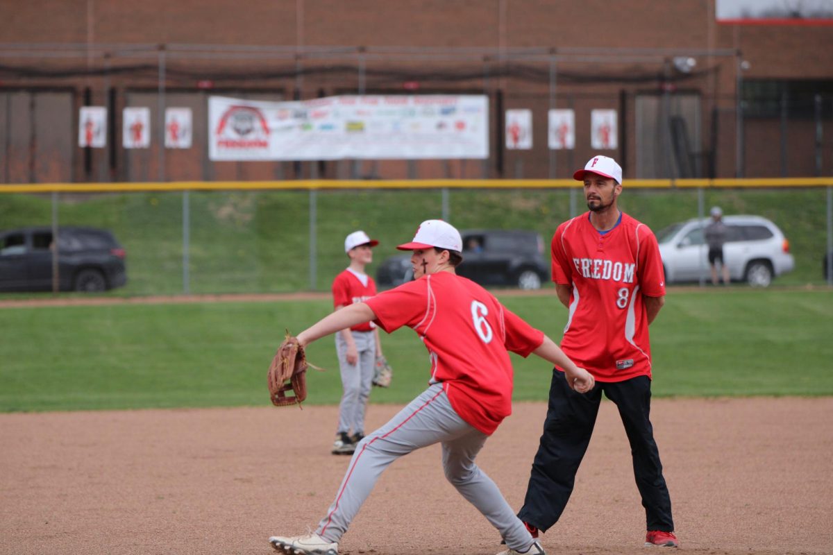 Kameron Brown (8) pitches the ball as Coach Mike Kuntz umpires from behind the mound while playing Ellwood on April 10 at home.