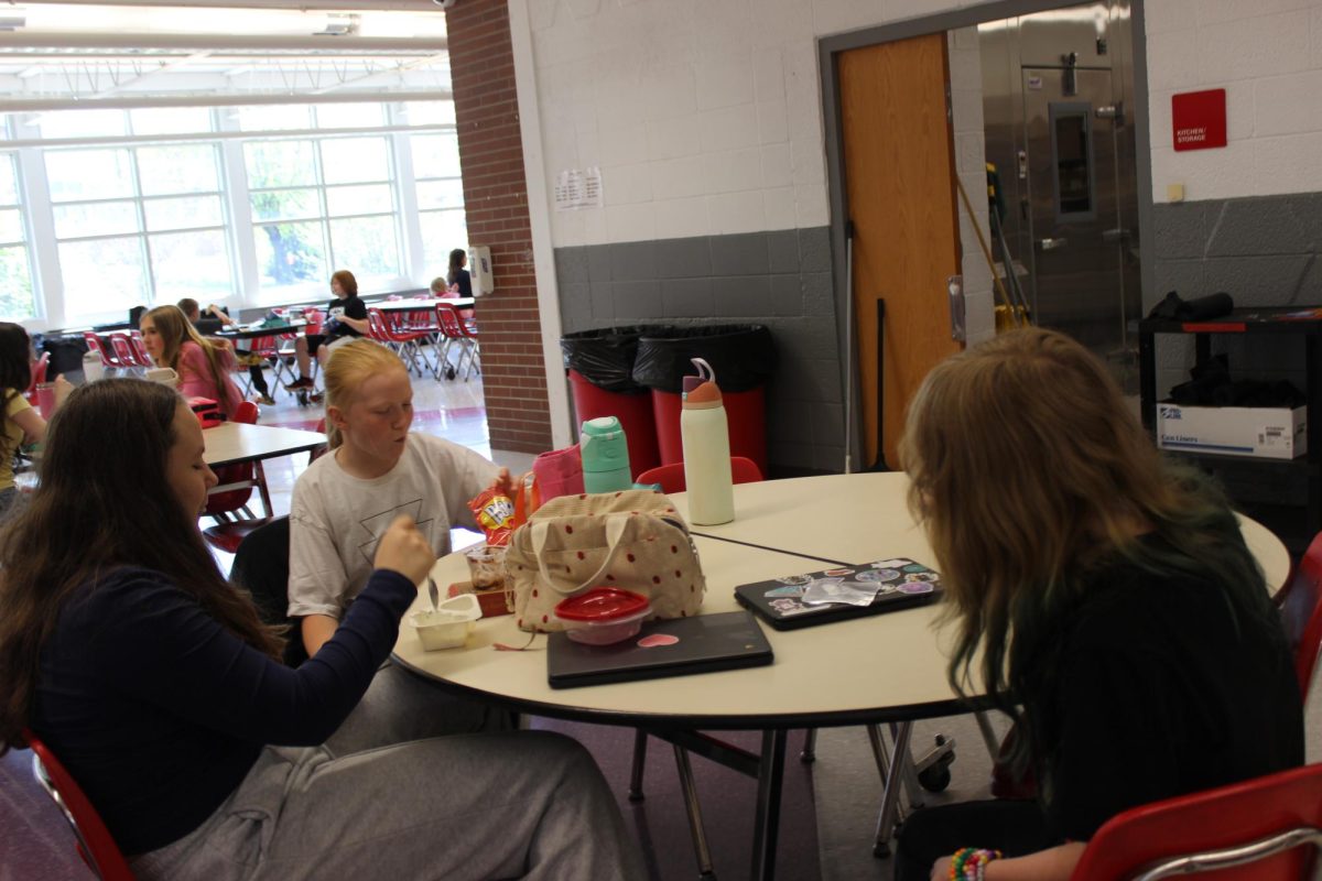 Alice Barnes (6), Raelyn Summervile (6), and Lorelei Carr (6), eat their lunch in the cafeteria during their lunch.