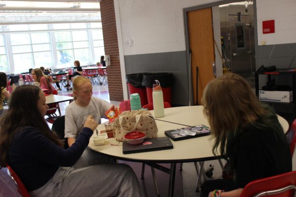 Alice Barnes (6), Raelyn Summervile (6), and Lorelei Carr (6), eat their lunch in the cafeteria during their lunch.