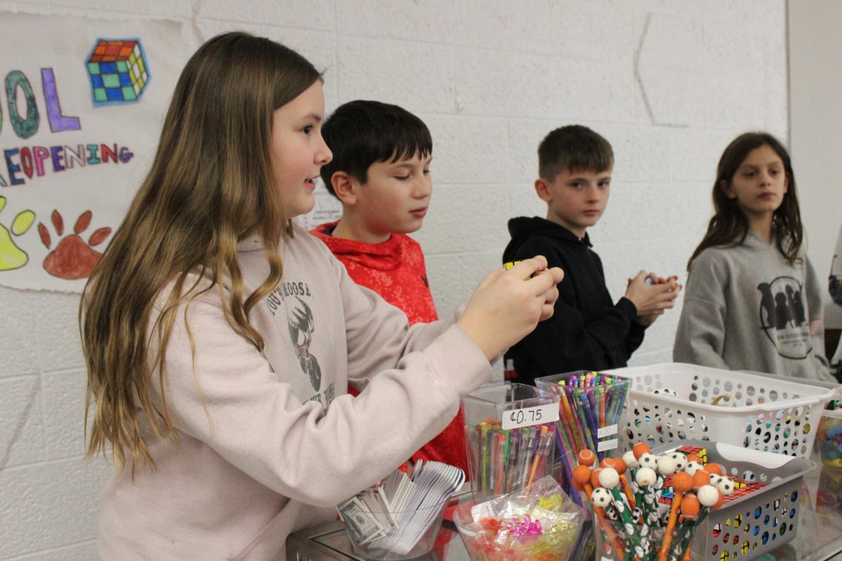 Jocelyn Carpenter, Elijah Miller, Amara Jacob and Owen Millward working the school store together.