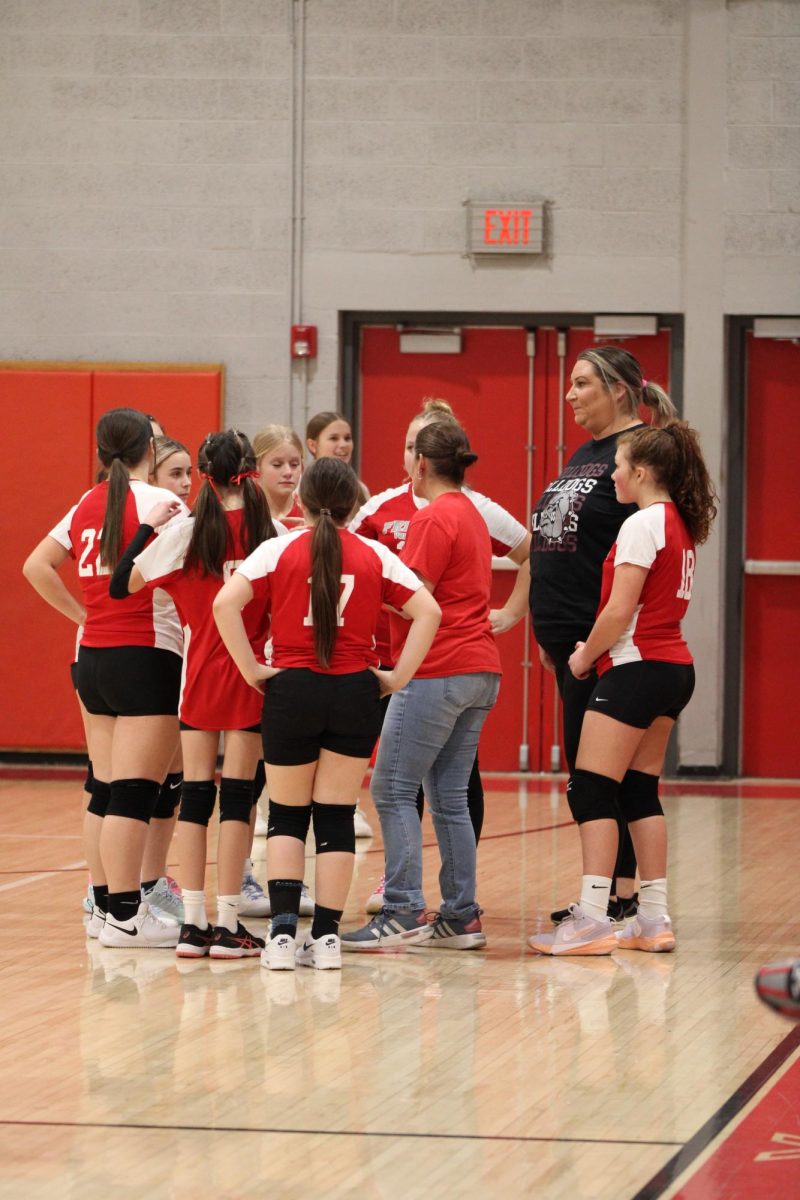 The seventh grade team gathers around Coach Melanie Smith and Coach Ashley Harvey during the home volleyball game against New Castle on February 18.
